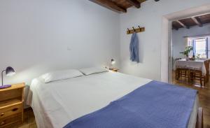 Un dormitorio con una gran cama blanca y una mesa en Sofaki Milos, en Tripití