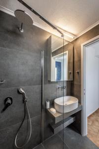 La salle de bains est pourvue d'une douche, d'un lavabo et d'une douche en verre. dans l'établissement Sofaki Milos, à Trypiti