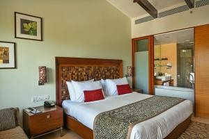 a hotel room with a bed and a dresser at Fariyas Resort Lonavala in Lonavala