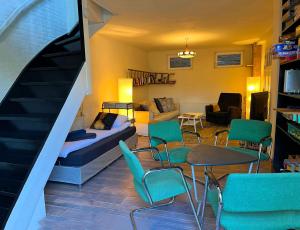 a living room with a bed and chairs and a staircase at Gastenverblijf Door de Poort in Tilburg