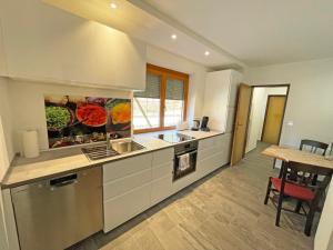 a kitchen with white cabinets and a table in it at Fewo Ziemer 2 in Piding