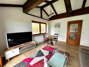 a living room with a flat screen tv and a table at Fewo Ziemer 2 in Piding