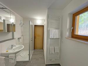 a white bathroom with a sink and a shower at Fewo Ziemer 2 in Piding