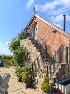 a set of stairs leading to a brick building at Lyde Cross Coach House in Hereford