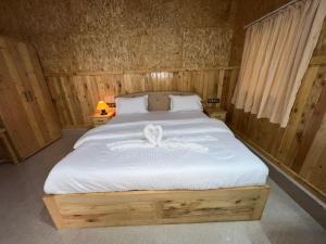 a bedroom with a large bed with a white blanket at santanas wooden cottages in Bogmolo +23 photos
