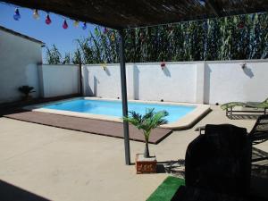 a swimming pool with a table and a palm tree at Casa con piscina privada en barrio tranquilo in Castelló d'Empúries