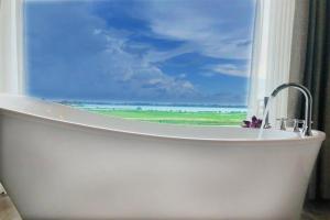 una vasca da bagno con finestra affacciata sull'oceano di Blue Wild - Yala - Plastic Free & Sustainable a Tissamaharama