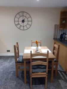 a wooden table and chairs with a clock on the wall at Alexandra place Skipton child and dog friendly in Skipton