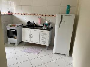 a small kitchen with a sink and a refrigerator at Apartamento com ar condicionado em Seabra in Seabra