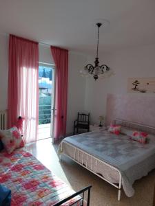 a bedroom with a bed and a couch and a window at La terrazza sugli ulivi in Toscolano Maderno