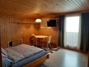 een slaapkamer met een bed, een tafel en een televisie bij Ferienwohnung Kuenzer Alm in Matrei in Osttirol