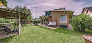 podwórko domu z trawnikiem w obiekcie Riverside Apartman**** Miskolc w Miszkolcu