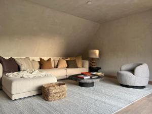 een woonkamer met een bank en een stoel bij luxe duplex met privé parking in Knokke-Heist