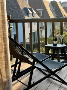 een stoel en een tafel op een balkon met een fles wijn bij luxe duplex met privé parking in Knokke-Heist