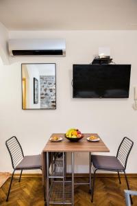 a dining room with a table and chairs and a television at Diocletians Heart Apartment in Split
