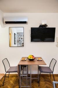 Un comedor con mesa y sillas y un televisor. en Diocletians Heart Apartment, en Split