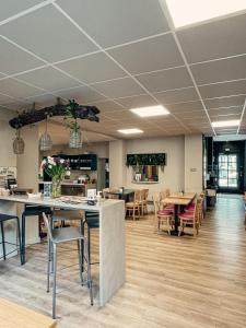 a large room with tables and chairs and a cafeteria at Garden Hotel Rennes Centre Gare in Rennes