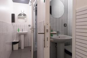 a white bathroom with two sinks and a mirror at HO36 Hostel in Lyon