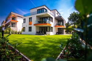 a white house with a green lawn in front of it at Villa Linett in Siófok