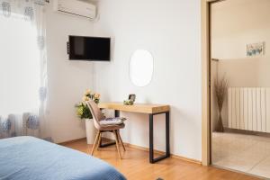 a bedroom with a desk and a chair and a bed at Apartments Nova Veruda in Pula