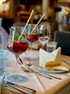een tafel met drie glazen wijn erop bij Lech Valley Lodge in Warth am Arlberg