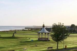 a gazebo in a field next to the ocean at Amazing views across the Moray Firth, Private Suntrap Patio, 300m from the Beach, off street parking! in Nairn