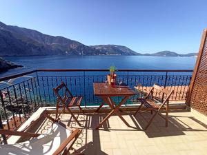 un tavolo e sedie su un balcone con vista sull'acqua di Paradise View ad Ásos