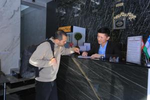 two men standing at a counter with at Hayot Plaza Hotel Yotoqxonasi in Yunusobod