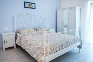 1 dormitorio con cama blanca y colcha blanca en A casa di Marica, en Sirolo