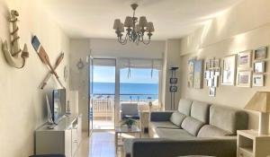 un soggiorno con divano e vista sull'oceano di MalagaSuite Front Beach Malagueta a Málaga