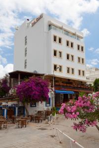 a white building with pink flowers in front of it at KUMBAHÇE GULET Hotel in Bodrum City