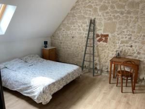 um quarto com uma cama, uma escada e uma secretária em Le Gîte de Moquesouris em Nazelles
