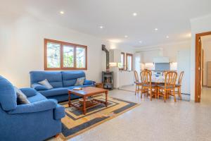 a living room with a blue couch and a table at Casa Mediterranea in Cala Santanyi