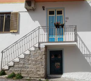 a white door leading to a balcony with a dog on it at La Finestra Vista Corsica in Santa Teresa Gallura