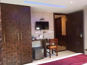 a room with a bed and a desk and a chair at Hotel A P Home's - A Boutique Hotel in Guwahati