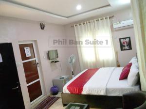 a bedroom with a bed and a window and a door at PhilBan Suites 1 in Ikeja