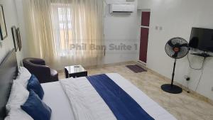 a hotel room with a bed and a fan at PhilBan Suites 1 in Ikeja