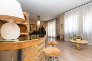 a lobby with a bar with stools and a table at Massaua Roomy Vintage Apartment in Turin