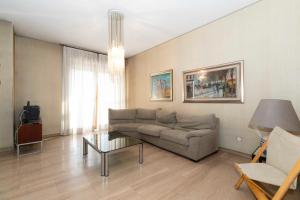 a living room with a couch and a table at Massaua Roomy Vintage Apartment in Turin