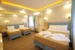 a hotel room with two beds and two tables at Hira Hotel in Istanbul +76 photos