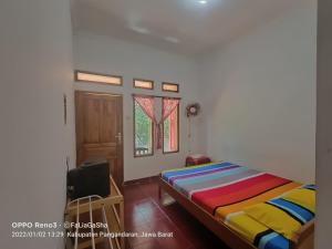 a bedroom with a bed and a window at Pondok Galang in Pangandaran