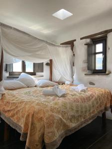 a bedroom with a large bed with a canopy at Wood & Stone - Paros in Aspro Chorio Paros