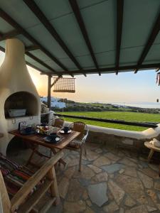 a patio with a table and an outdoor oven at Wood & Stone - Paros in Aspro Chorio Paros