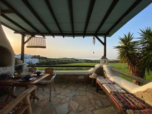 a patio with a couch and a table and chairs at Wood & Stone - Paros in Aspro Chorio Paros +19 photos