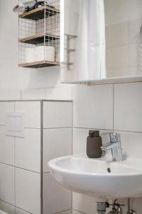 a white bathroom with a sink and a mirror at FLATLIGHT - Shiny Apartment - Balcony - Central - Kitchen in Hildesheim