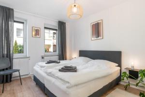 1 dormitorio con 1 cama blanca grande y toallas. en FLATLIGHT - Shiny Apartment - Balcony - Central - Kitchen, en Hildesheim