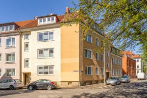 an apartment building with cars parked in front of it at FLATLIGHT - Shiny Apartment - Balcony - Central - Kitchen in Hildesheim