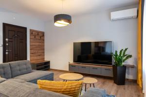 a living room with a couch and a tv and a table at Апартаменти 22 in Velingrad