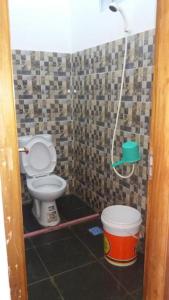 a small bathroom with a toilet and a bucket at Pondok Galang in Pangandaran