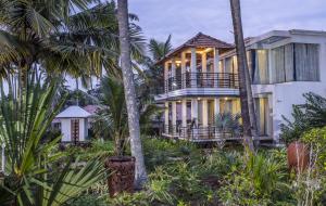 a house on the beach with palm trees at Coconut Cove Varkala in Varkala